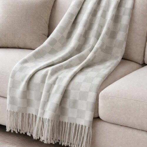 Plaid vichy grigio chiaro e bianco con frange sul bordo, in tessuto morbido.