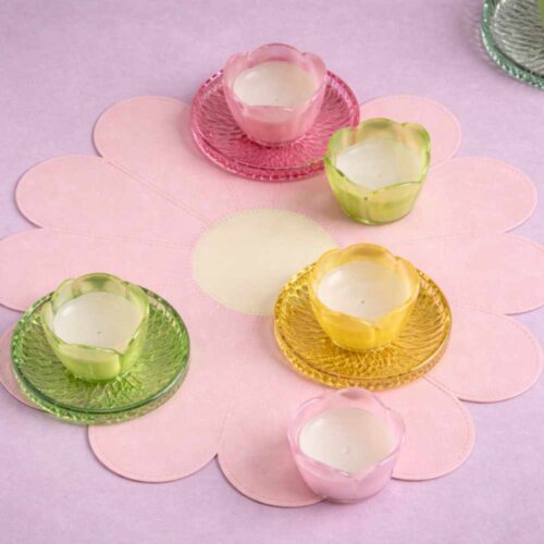 Tovaglietta a forma di margherita rosa cipria con centro avorio, finitura effetto pelle e impunture decorative.