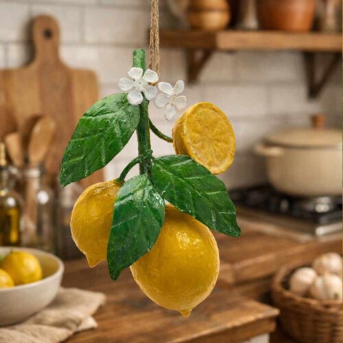 Decoro limoni da appendere in metallo con tre frutti gialli, foglie verdi, piccoli fiori bianchi e cordino in fibra naturale.