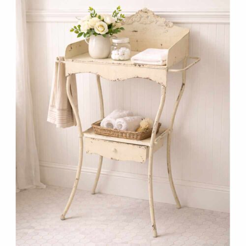 Mobiletto in metallo avorio stile shabby con alzatina decorata, maniglie laterali e ripiano con cassetto.