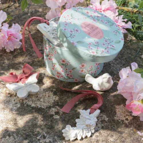 Set regalo Mathilde M Fleur de Cerisier con scatola rotonda verde acqua a fiori di ciliegio e 5 decori profumati in gesso bianco con nastri rosa.