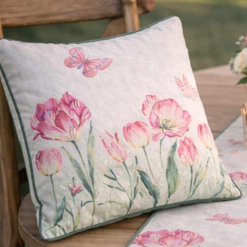 Cuscino quadrato bianco con ricamo di tulipani rosa, farfalle e bordino verde scuro a contrasto.
