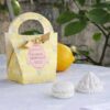 Boîte cadeau Mathilde M Citron Meringué avec deux décorations en plâtre parfumées blanches en forme de macarons et de bonbons, dans un sachet jaune pastel avec nœud.
