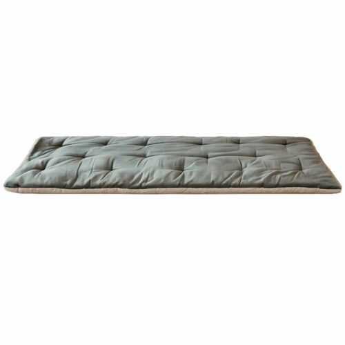 Dessus de canapé matelassé en velours vert sauge de Jaipur avec bordure beige, placé sur le canapé avec housse florale assortie.