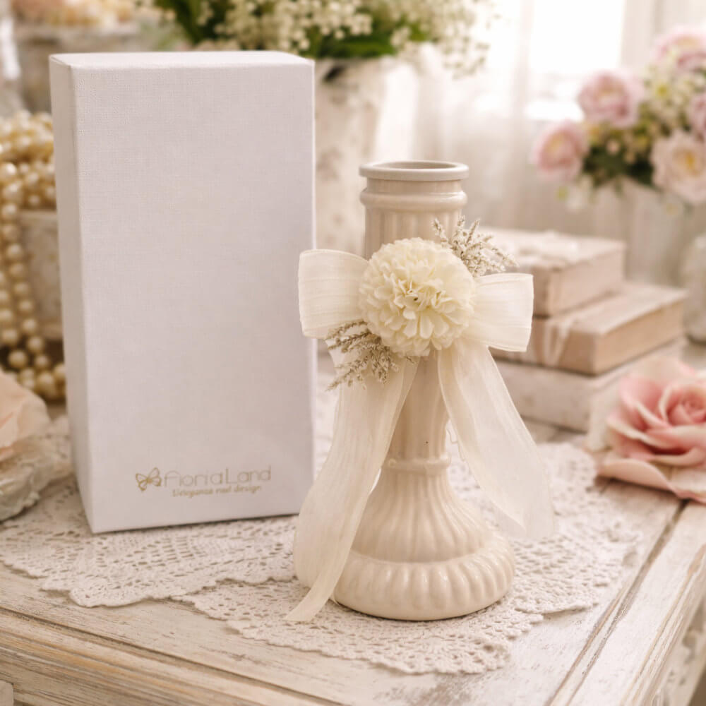 Candelabro in ceramica beige Fiori di Lena con dalia avorio e fiocco, accanto alla scatola regalo, ideale come bomboniera shabby chic e punto luce per consolle.