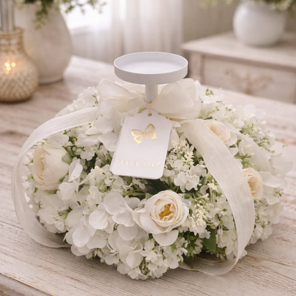Candelabro Fiori di Lena con hortensias blancas y niebla blanca, lazo marfil y portavelas de platillo, sobre mesa de madera Shabby Chic.