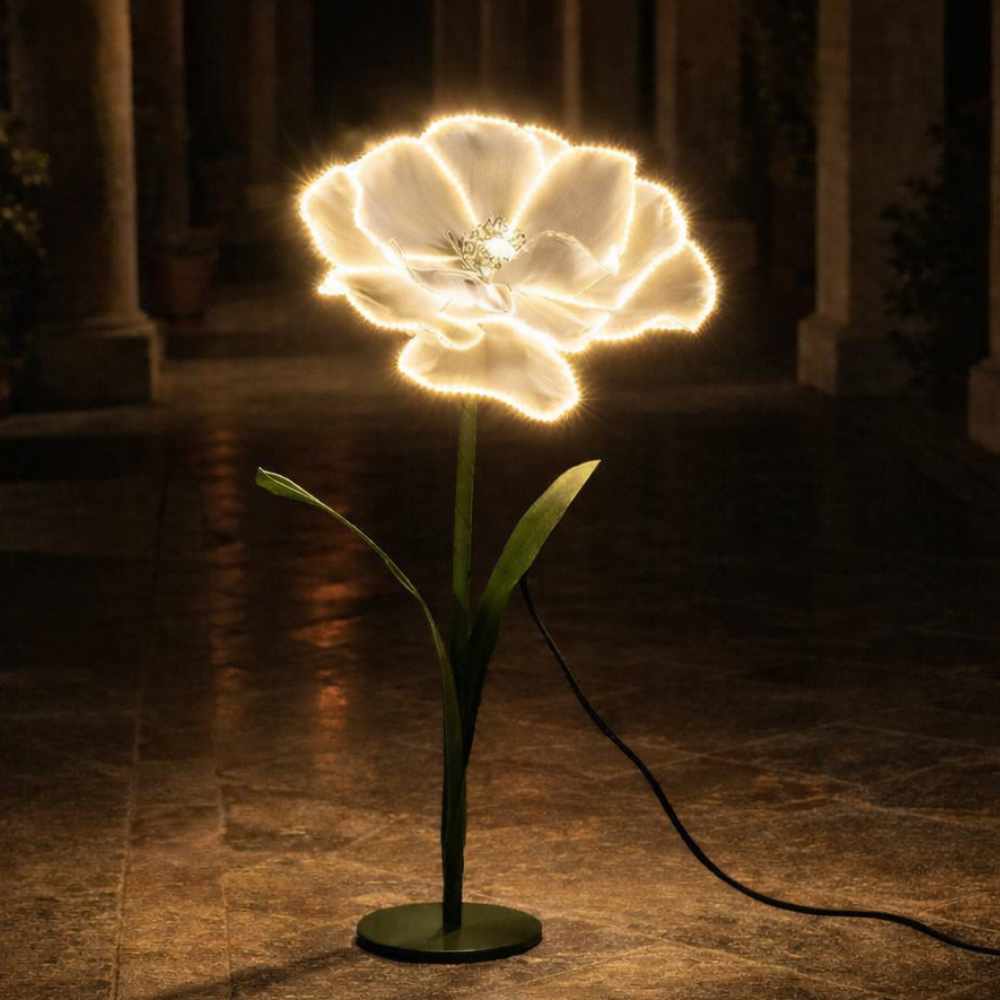 Fleur décorative blanche en forme d'anémone avec contour LED, tige et feuilles vertes, base ronde verte et câble électrique.