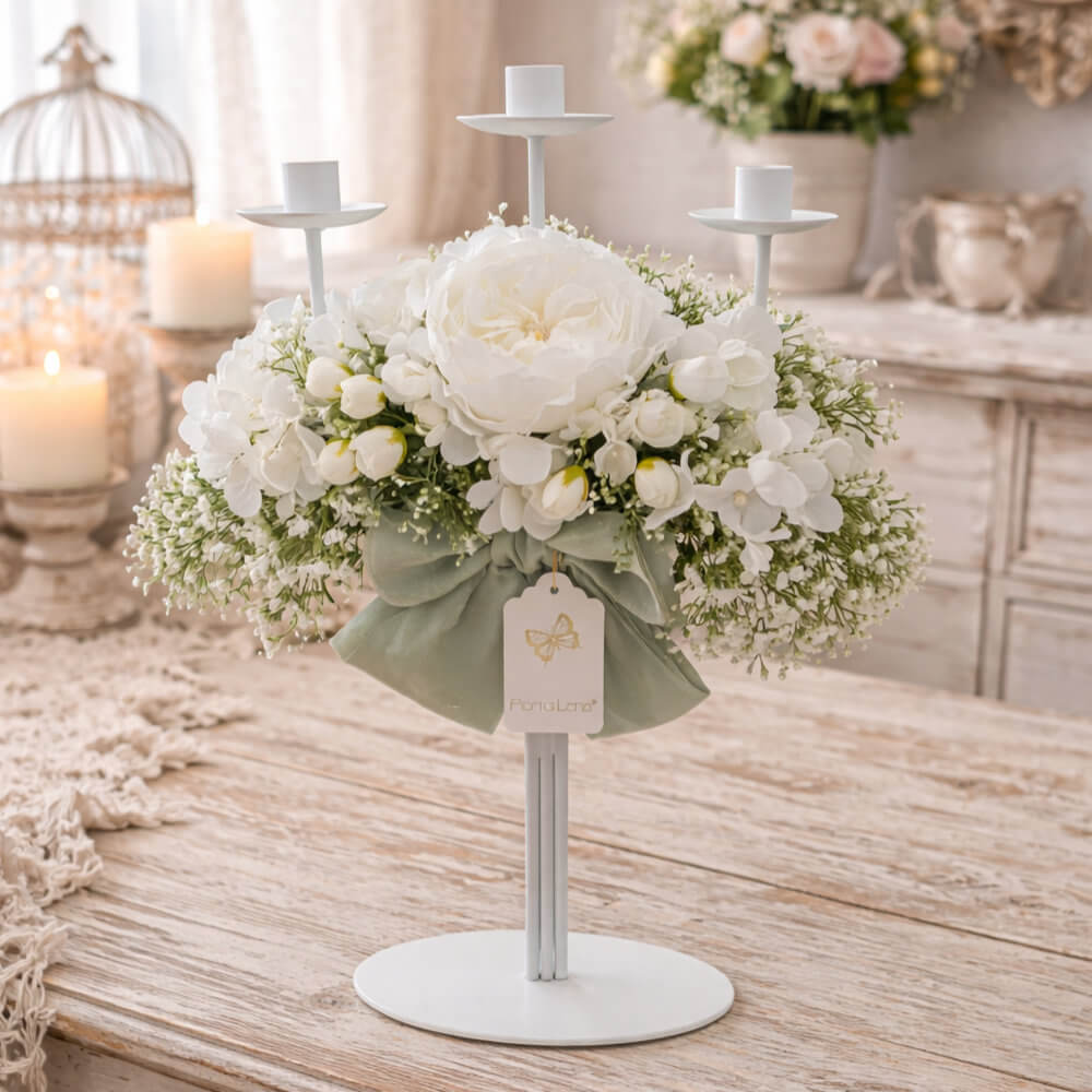 Candeliere a 3 fiamme Fiori di Lena con peonia bianca e decori floreali candidi, fiocco verde salvia, su tavolo in legno shabby chic.