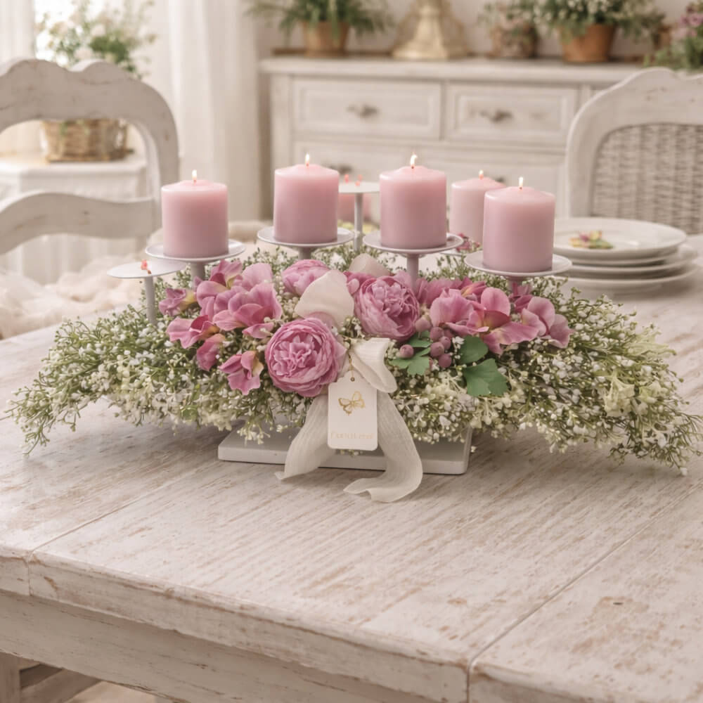 Candelabro a 4 fiamme Fiori di Lena con ranuncoli rosa e fiorellini bianchi su base chiara, centrotavola shabby chic su tavolo in legno.
