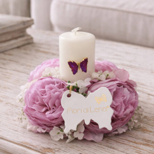 Corona Fiori di Lena con ranuncoli glicine e candela con farfalla applicata, centrotavola shabby chic su superficie chiara, con tag brand.