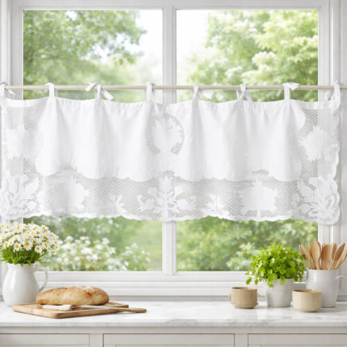 Mantovana Matilde L'Atelier 17 in cotone bianco con fascia in pizzo puntinato e ricami floreali tridimensionali su tulle, bordo a festoni e fissaggio a fiocchi, installata su finestra di cucina in stile shabby chic.