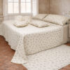 Trapuntino Fiore di Primavera L'Atelier 17 in poliestere avorio con stampa a mazzetti di rose rosa, trapuntatura a rombi e bordo in pizzo macramè, abbinato a due federe coordinate su letto in camera shabby chic.