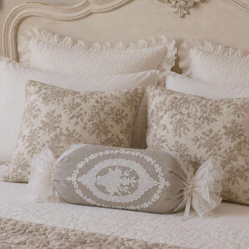 Cuscino caramella Blanc Mariclò beige con ricamo Sangallo a ghirlanda bianca, estremità arricciate e fiocchi decorativi