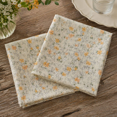 Coppia di tovaglioli in garza di cotone color avorio con stampa floreale gialla e dettagli botanici, stile shabby chic.