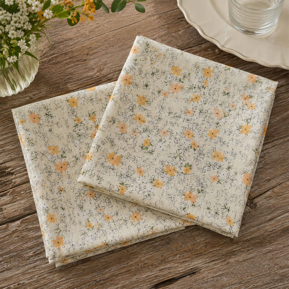 Coppia di tovaglioli in garza di cotone color avorio con stampa floreale gialla e dettagli botanici, stile shabby chic.