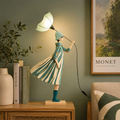Lampada artigianale SKITSO Little Girl Luts alta 85 cm, con base in legno di faggio, abito a righe verde acqua e crema e paralume a forma di ombrello verde acqua.