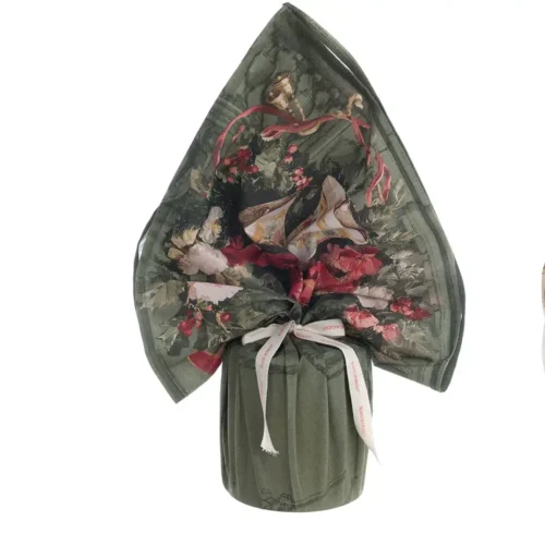 Foulard natalizio verde Blanc Mariclò in cotone con stampa di campane, fiori, agrifoglio e nastri rossi, ideale come centrotavola o porta panettone della collezione Calessi e Calessini.