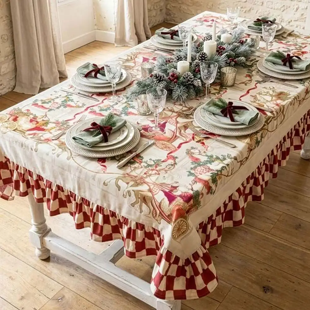 Nappe « Blanc MariClò » en coton avec un volant de 15 cm, imprimé de Noël représentant des calèches, des chevaux et des guirlandes, ornée d'un volant à carreaux rouges et ivoire, dimensions : 190 x 310 cm.