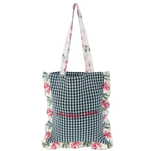 Borsa in tessuto con fantasia vichy bianco e blu, ricamo rosso "Custodisco l'Amore", volant e manici con stampa floreale nei toni del rosa e del verde.