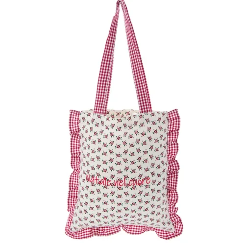 Borsa in tessuto con stampa di piccoli motivi natalizi su fondo chiaro, ricamo "Natale nel Cuore", volant e manici in fantasia vichy rosso e bianco.