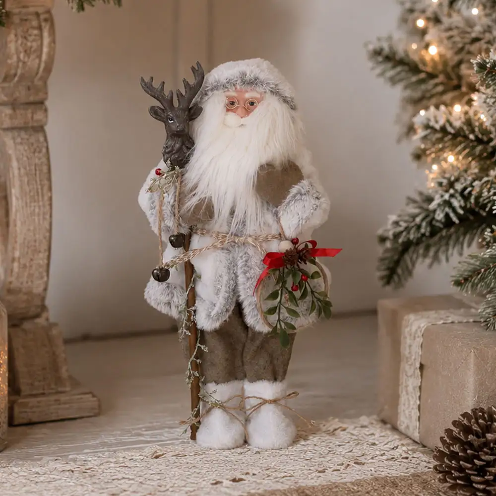 Babbo Natale di montagna alto 45 cm con abito bianco, bastone con testa di cervo e ghirlanda decorata.