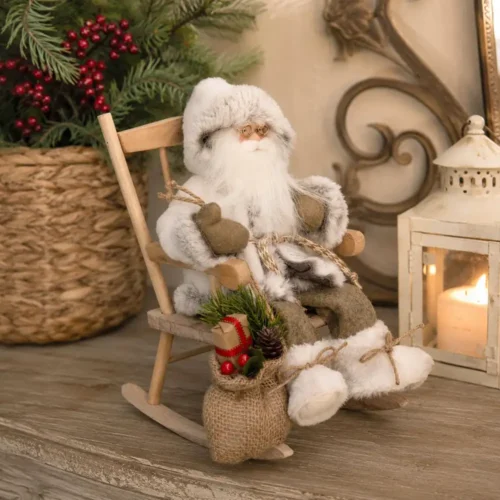 Babbo Natale decorativo vestito di bianco seduto su sedia a dondolo in legno, con sacco in juta e decorazioni natalizie, alto 30 cm.