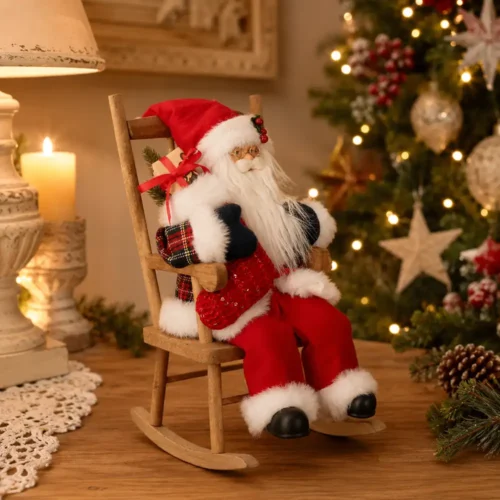 Babbo Natale rosso seduto su sedia a dondolo in legno con pacco regalo, barba bianca, occhiali dorati e dettagli tartan, alto 30 cm.