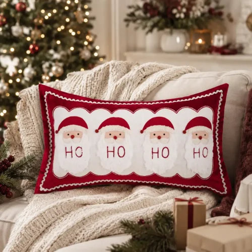 Cuscino rettangolare rosso e bianco con quattro Babbo Natale applicati, barbe morbide e scritta Ho Ho Ho Ho.