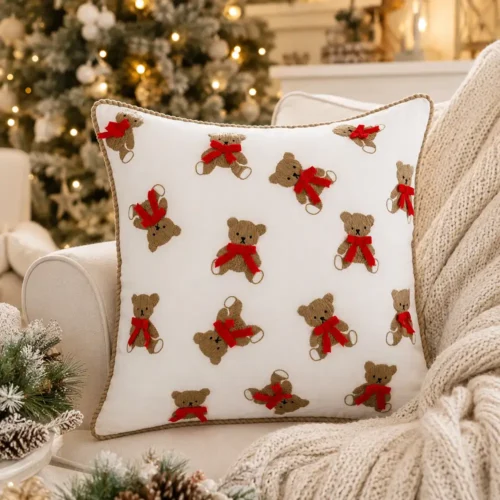 Cuscino bianco Blanc Mariclò con orsetti beige ricamati, fiocchi rossi in rilievo e bordo a cordoncino tortora.
