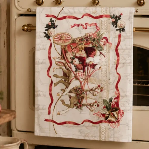 Torchon de Noël Blanc Mariclo en coton, orné d'un traîneau du Père Noël tiré par deux chevaux, de décorations florales, de clochettes et de rubans rouges, issu de la collection Calessi et Calessini.