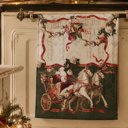 Torchon de Noël Blanc MariClò en coton, représentant le Père Noël dans un traîneau tiré par deux chevaux, avec des guirlandes florales, des clochettes et des rubans rouges, issu de la collection « Calessi e Calessini ».