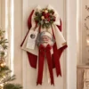 Fioccò rosso e bianco con tamburello di Babbo Natale, palline dorate, bacche rosse, pigne innevate e lunghi nastri.