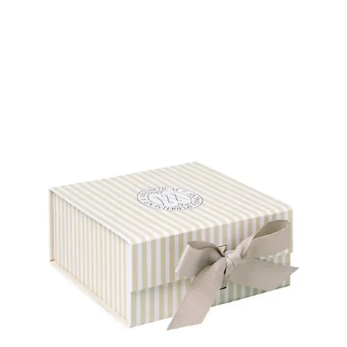 Petite boîte cadeau Mathilde M à rayures beige et blanches, avec logo sur le couvercle et nœud frontal en ruban coloris tourterelle.
