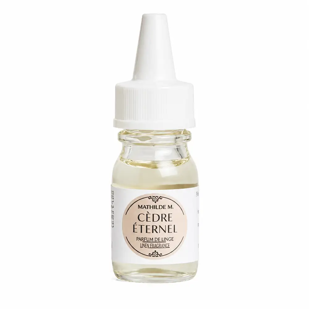 Superconcentrado Mathilde M Cèdre Éternel de 10 ml en un frasco de cristal transparente, con un líquido de color amarillo claro y un tapón dosificador blanco.