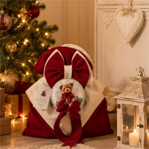Sacco delle Dolcezze Dolce Teddy rosso e panna con grande fiocco, tamburello con orsetto e piccolo fiocco rosso decorativo.