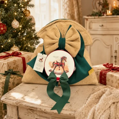 Sacco delle Dolcezze Madame Fioccò beige e verde con tamburello, cavallo a dondolo e fiocchi decorativi.