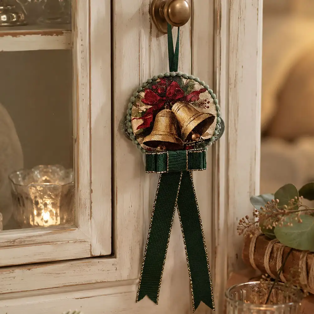 Tamburello Rintocco di Natale con campane dorate, fiocco rosso, bordo verde salvia e nastri verdi pendenti.