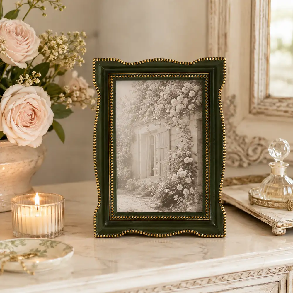 Portafoto Blanc Mariclò Vivienne in resina verde oliva con bordi sagomati e piccoli decori dorati a rilievo, formato foto 10x15 cm.