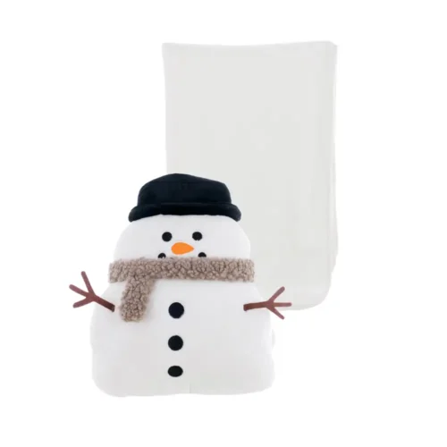 Coussin en forme de bonhomme de neige blanc avec chapeau noir, écharpe beige et nez orange, devant un plaid blanc.